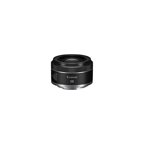 Several prime camera lenses arranged on a warm neutral surface