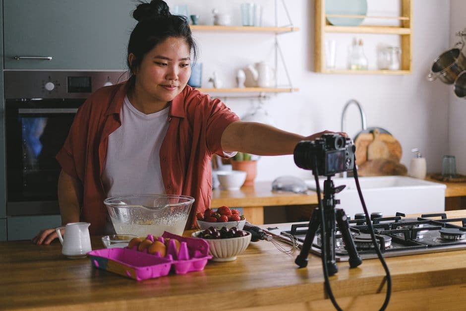 A creator filming themselves with a mirrorless camera on a tripod