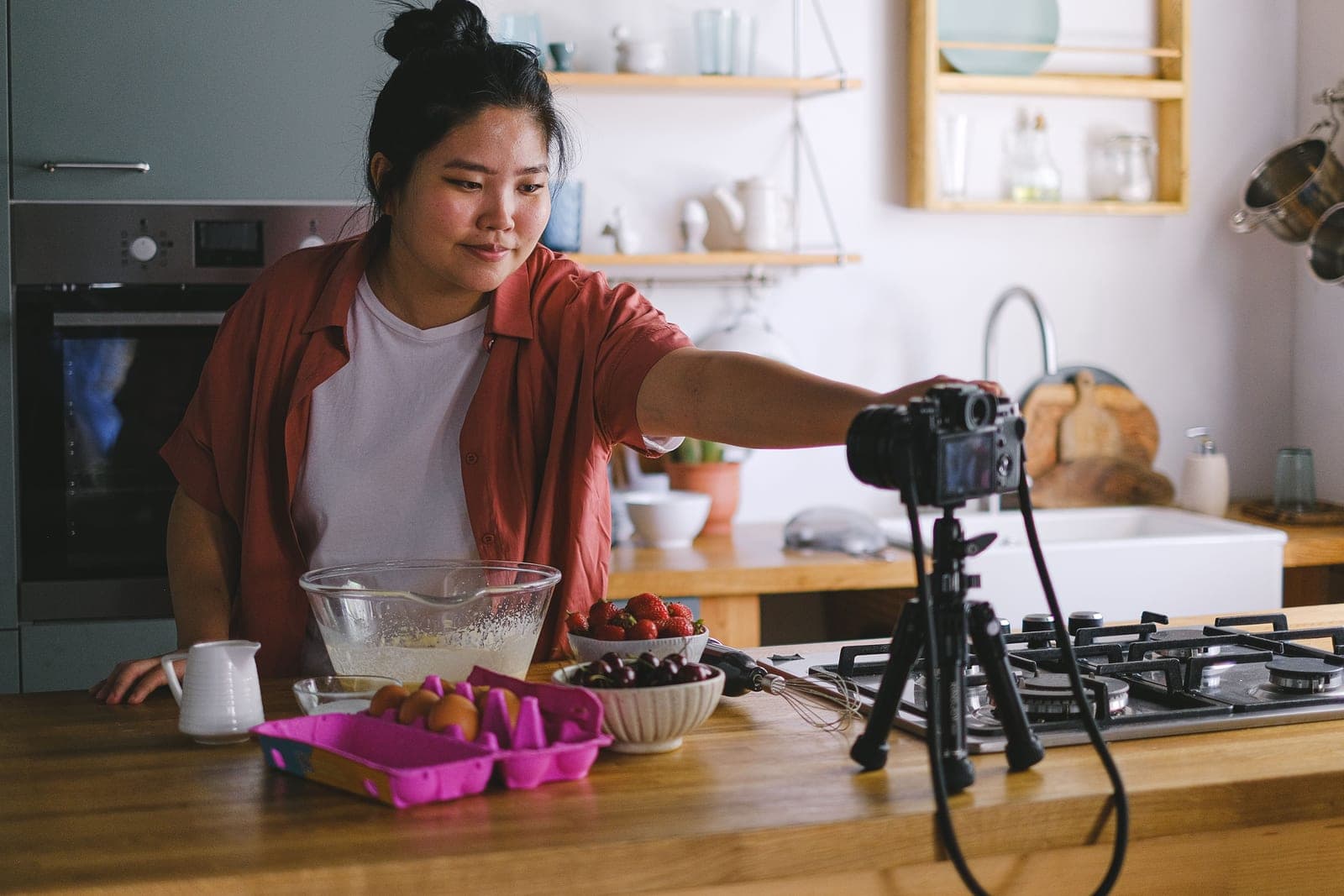 A creator filming themselves with a compact mirrorless camera on a tripod